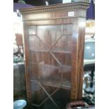 A darkwood astragal glazed corner cupboard