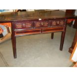 A Chinese carved three drawer hall table.