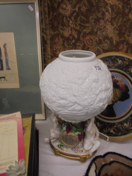 A 20th century porcelain table lamp featuring cherubs with a milk glass embossed shade.