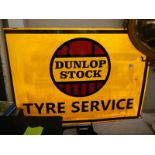 A Dunlop Stock Tyre Service sign.