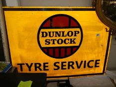 A Dunlop Stock Tyre Service sign.