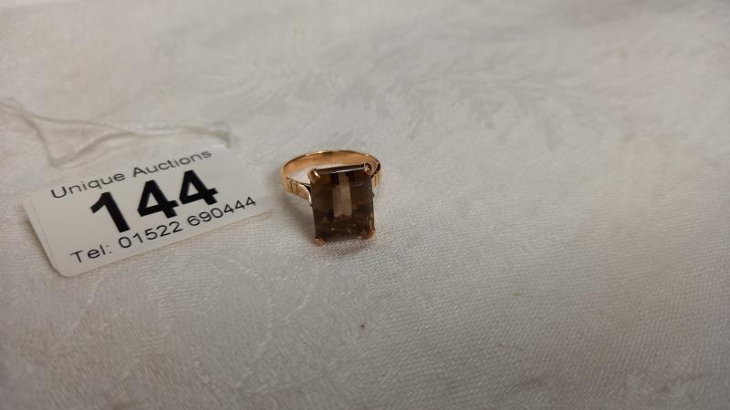 A gold ring set with smoky quartz in openwork mount, size O, 5.7 grams.