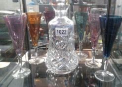 A cut glass decanter and 6 coloured glass flutes