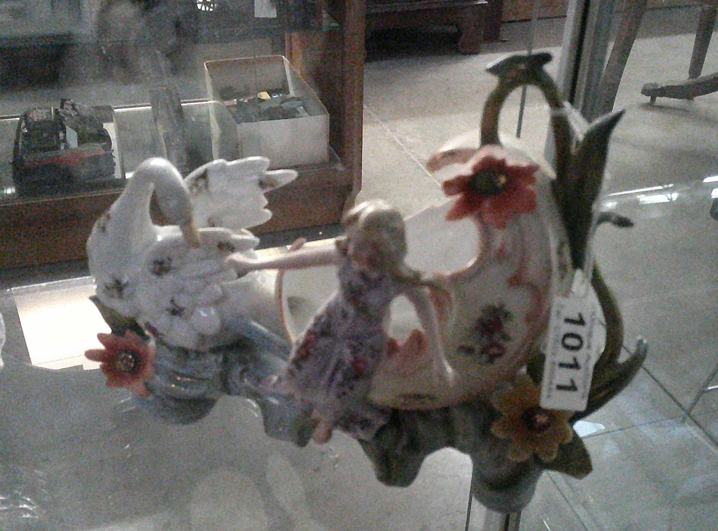 A porcelain carriage with swan and lady figure, (damage to thumb on right hand).