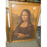 A framed print on silk of the Mona Lisa. 74 x 49 cm.