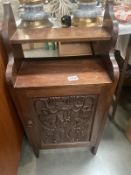 A mahogany wall cupboard with carved door