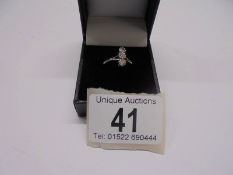 A three stone 18ct gold diamond ring, size J half, 1.9 grams.