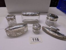 Five assorted silver topped trinket pots and a silver nail polisher.