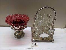 A four bottle cruet and a cranberry glass sugar bowl on plated base, (glass a/f).