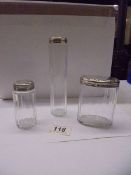 Three glass bottles with silver tops, Robert Stilby, London 1931. (part of a dressing table set).