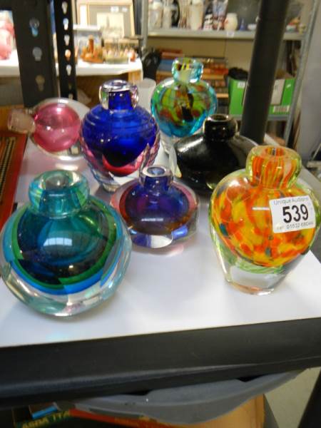 Seven heavy coloured glass bud vases.