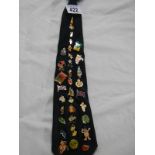 A collection of pin badges on a tie.