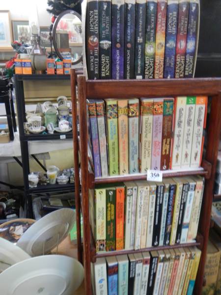 Four shelves of good paper back books.