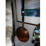 A Victorian copper warming pan.