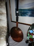 A Victorian copper warming pan.