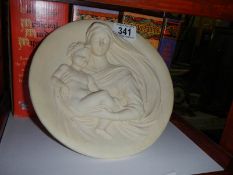 A circular plaque featuring Madonna and Child,