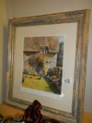 A framed and glazed thatched cottage scene.