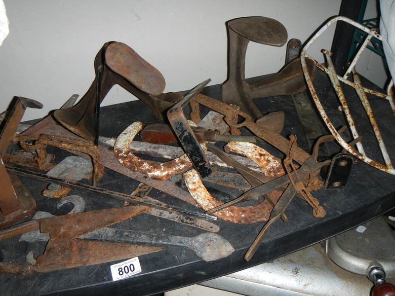 A shelf of metal items including shoe lasts.