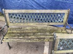 A wooden garden bench with metal ends and trellis style back