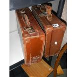 Two small vintage suitcases.