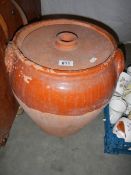 A large lidded terracotta pot.