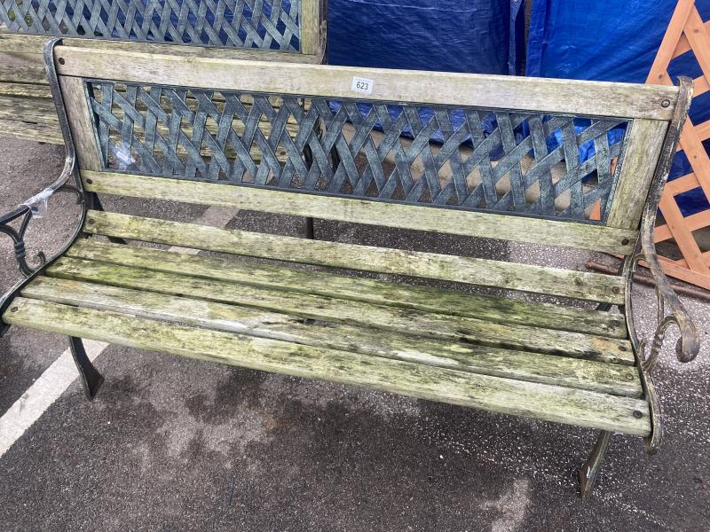 A wooden garden bench with metal ends and trellis style back