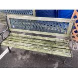 A wooden garden bench with metal ends and trellis style back