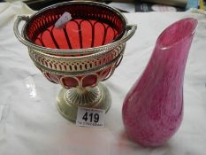 A silver plate sugar bowl with cranberry glass liner and a studio glass vase.