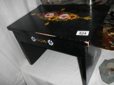 A foot stool painted in the style of barge ware.