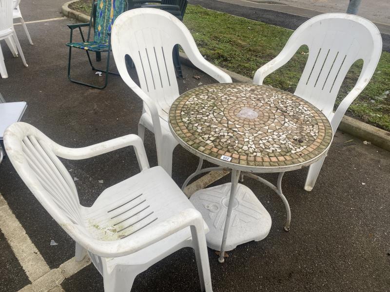 3 plastic garden chairs and a mosaic tile top table