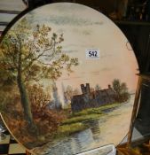 A hand painted wall plaque of an old building by a lake signed by Doulton artist M W K Blair. the