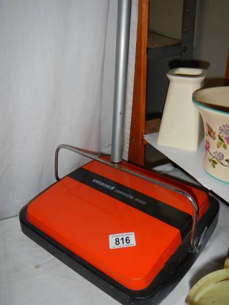 A Bissell carpet sweeper.