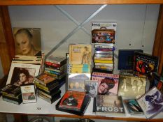 A varied selection of music cassettes and 45 rpm records.