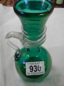 An early 20th century irridescent green glass vase with wrap around handle.