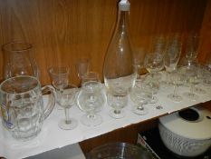 A decanter and a quantity of glasses.