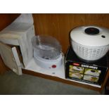 A boxed vegetable steamer and a salad spinner, both look unused.