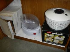 A boxed vegetable steamer and a salad spinner, both look unused.