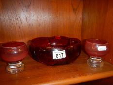 A vintage ruby glass fruit bowl and two footed glasses.