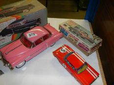 A boxed tinplate friction 1950's Cadillac and a clockwork rally car.