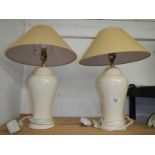 A pair of cream pottery table lamps with shades, height 62 cm.