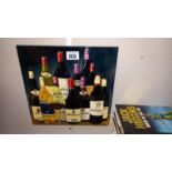 A large hand painted tile/plaque with back stand and hook featuring bottles of wine