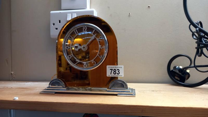 An art deco amber glass on chrome electric mantle clock