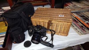 A wicker basket, a 2 Lowepro camera bag, a Lowepro camera case & a Canon camera