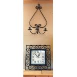 A decorative wall clock and candle sconce