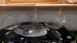 A large glass fish plate and 3 small fish plates