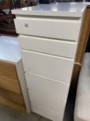 A tall white dressing chest of drawers with mirror top