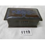 A small bronze box with blue inlay.