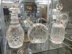 Three unusual shaped glass decanters.