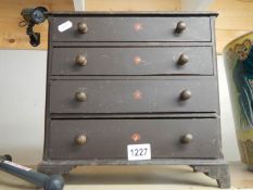 A miniature pine chest of drawers.