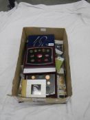 A large box of assorted coins and coin sets.